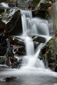 Waterfall coming down on dark rocks