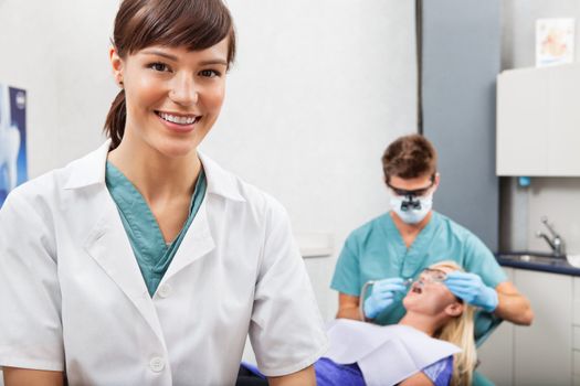 Portrait of dental assistant smiling with dentistry work in the background