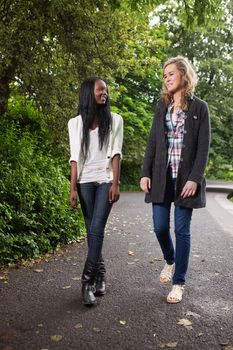 Two young women enjoying walk in the park