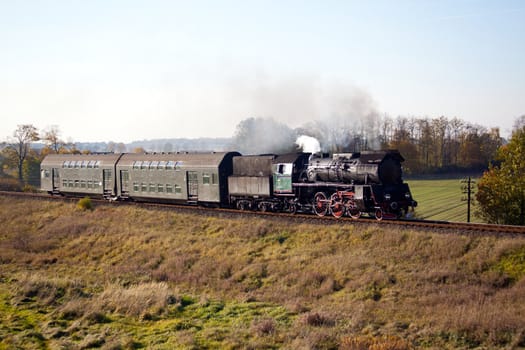 Old retro steam train passing through polish countryside
