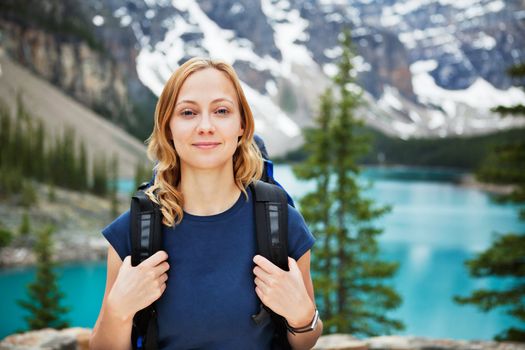 Portrait of attractive female hiker with her backpack against scenic view