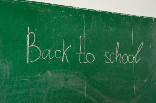 Green chalk blackboard written Back To School with white chalk