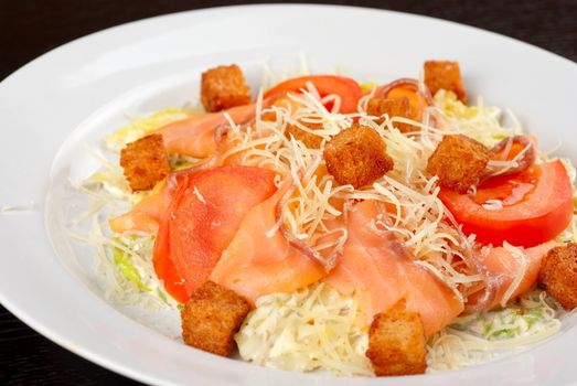 Salad of lettuce, chinese cabbage, tomato, garlic rusk, parmesan cheese, sauce and smoked salmon filet
