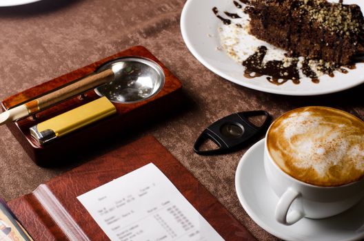 check, ashtray, cigar, lighter and coffee at restaurant table
