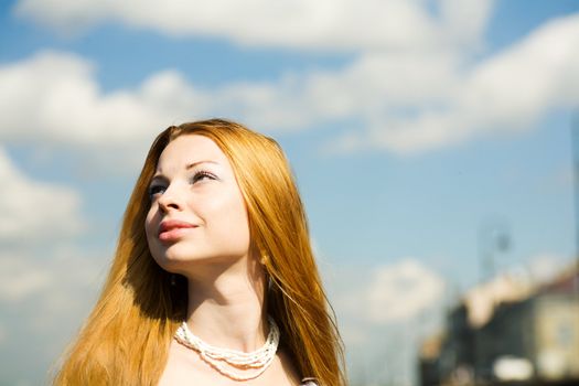 Young woman looking up to the sun portrait