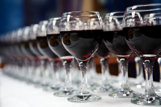 Glasses of red  wine in a row on table