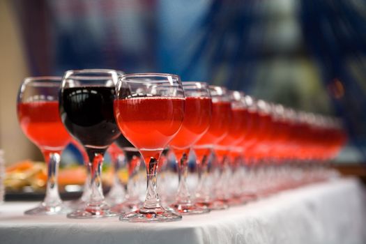 Glasses of red and pink wine in a row on table