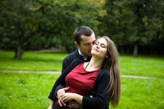 Two young lovers enjoying each other in park