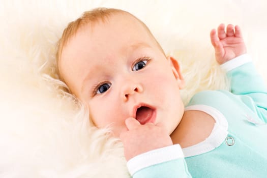 Baby Portrait looking straight at you lying on white fluffy fur