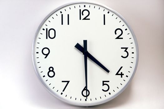 A big and white clock on the wall