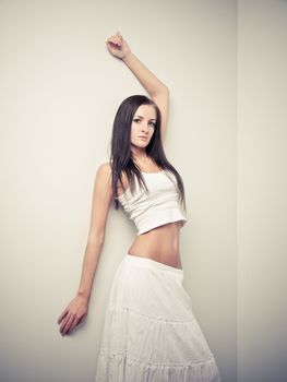 Model in white dress posing in a studio