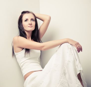 Model in white dress posing in a studio