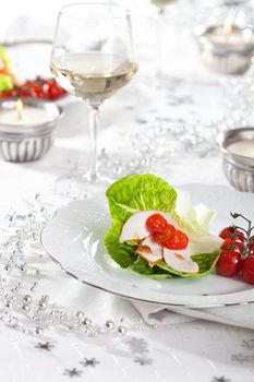 Pretty christmas table setting with small appetizer on plate