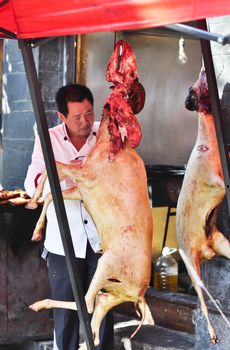 Lijiang, China - July 20:  A Market man butchering and cleaning the goats in the market on July 20, 2011.  A very common site in China.