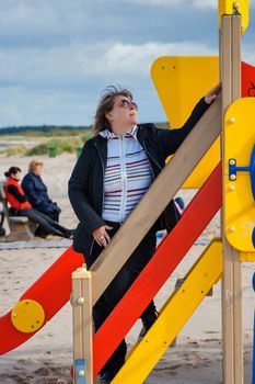 Mature  woman relaxing in dune at the Baltic sea in autumn day.