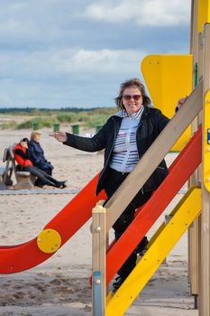 Mature  woman relaxing in dune at the Baltic sea in autumn day.