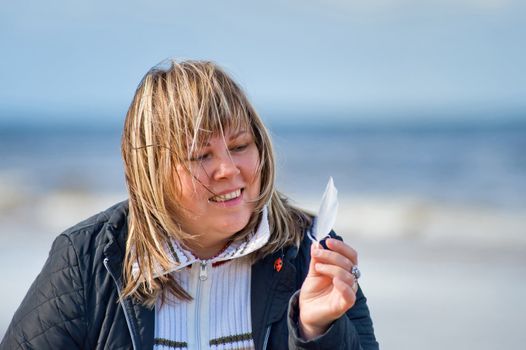 Portrait of mature chubby woman relaxing at the Baltic sea in autumn day.