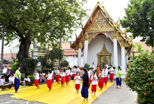Bangkok, Thailand - December 19:  Some students with teachers learning Thai dancing outside of a famous temple in Bangkok on December 19, 2010