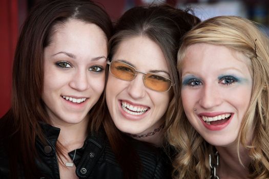 Three happy Caucasian teenaged girlfriends with big smiles