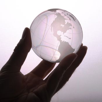 environmental protection or business concept with glass globe in hand isolated on white