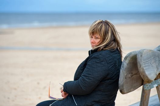 Mature woman relaxing at the Baltic sea in autumn day.