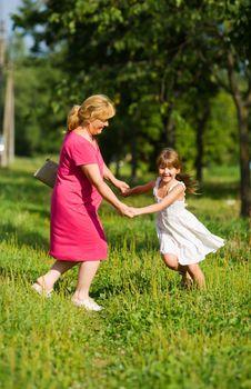 Grandmother with child dancing together outdoors