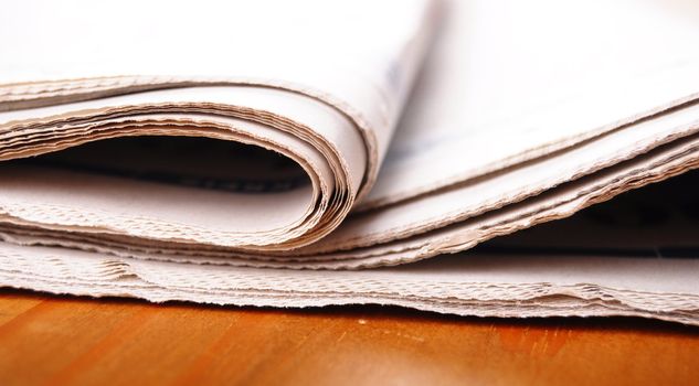 stack of newspaper on desktop showing news concept