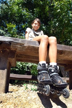 caucasian teenage girls with rollers resting on bench outdoor in park at summer