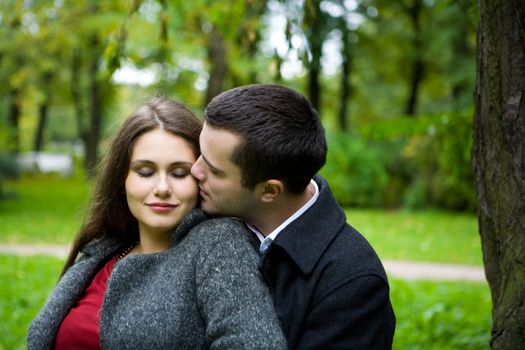 Two young lovers enjoying each other in park