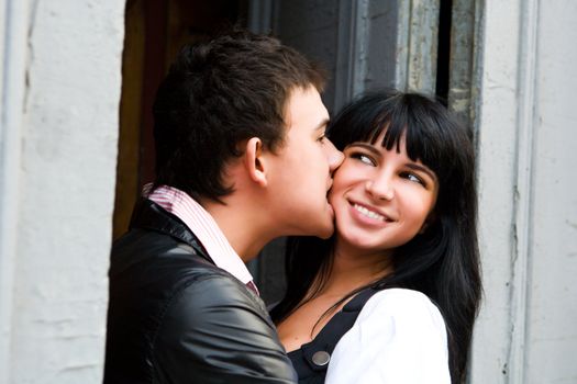 Happy young kissing couple portrait in doors