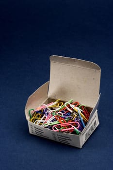 paper clips in box on blue background