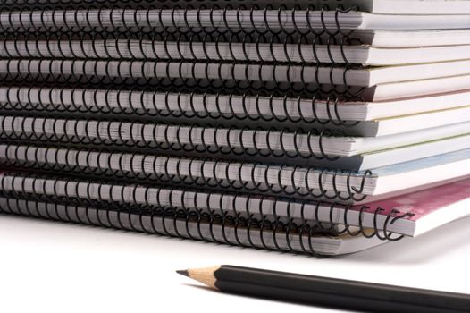 A pile of notebooks with pen