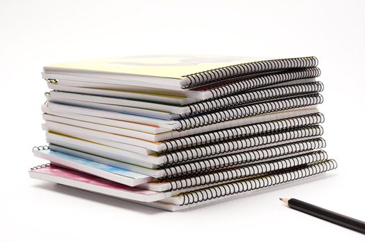 A pile of notebooks with pen