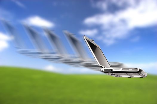 Laptop flying over a beautiful green meadow