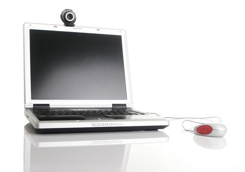 Laptop with a mouse and a webcam over a table with reflection