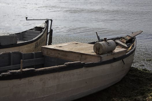 Two fishing boats  standing on the sand of a beach