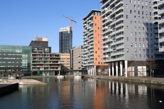 New apartment flats around a pond, office tower under construction