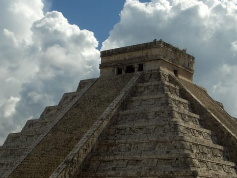 A pyramid at Chichen Itza, Mexico, with dramatic clouds.