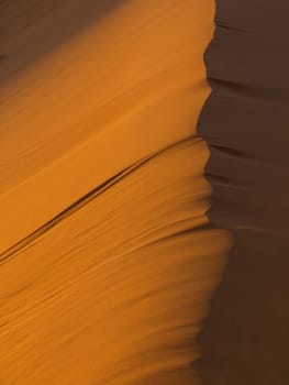 The ridge of a sand dune at sunset, in Morocco.