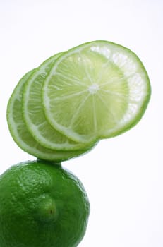 A lime, sliced and fanned out, balanced on another lime.