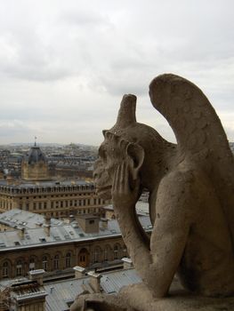 A view of Paris from the Notre Dame Cathedral, with a pensive gargoyle.