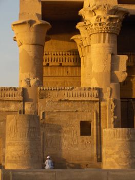 An Egyptian man examining a wall at the Kom Ombo Temple in Egypt