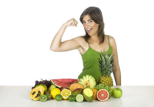 Beautiful and strong healthy woman with a lot of fruits in front of her