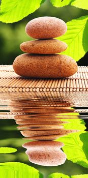 zen stones and water reflection showing spa concept