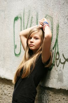 The girl - teenager on a background of a wall