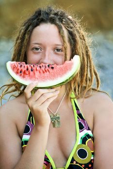 young beautiful smiling dreadlock woman with a slice of watermelon