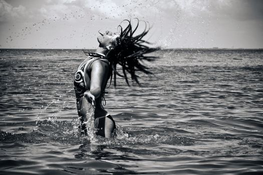 girl emerges from the water with splash. Black and white photo
