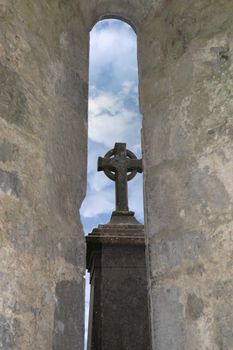 celtic cross through an old church arch window