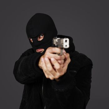 black dressed man with gun in studio