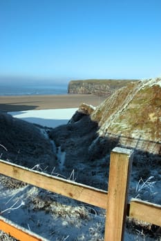 snow covered view of atlantic ocean and ballybunion beach and cliffs on a frosty snow covered winters day